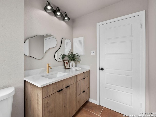 bathroom with tile patterned flooring, vanity, and toilet