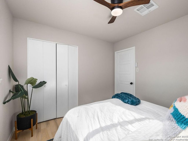 bedroom featuring ceiling fan, a closet, and light wood-type flooring