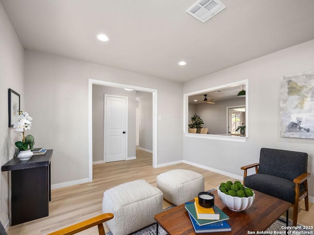 living area with light wood-type flooring and ceiling fan