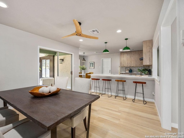 dining space with ceiling fan and light hardwood / wood-style floors