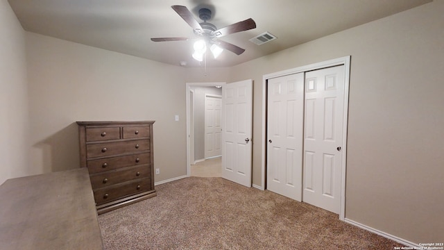 unfurnished bedroom with ceiling fan, light carpet, and a closet