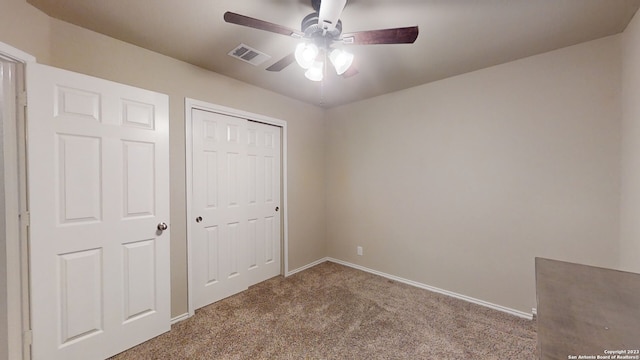 unfurnished bedroom with ceiling fan, a closet, and carpet