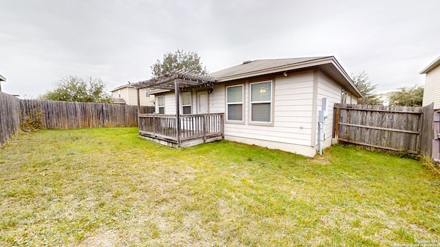 rear view of house featuring a lawn, a deck, and a pergola