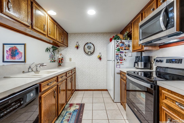 kitchen with sink, light tile patterned floors, and stainless steel appliances