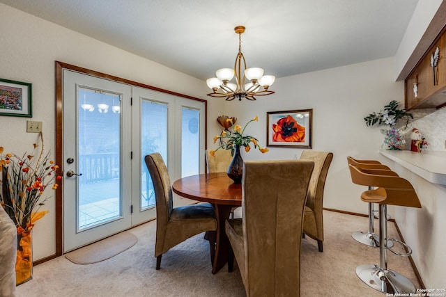 carpeted dining room featuring a chandelier