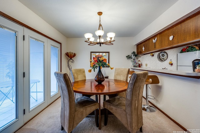 dining area with light carpet and a chandelier