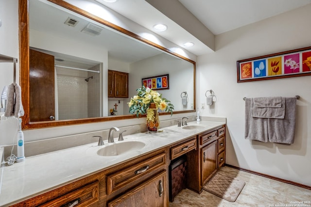 bathroom featuring a tile shower and vanity