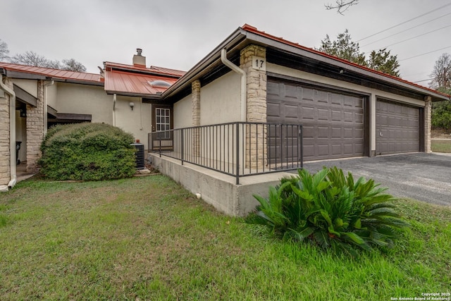 view of property exterior with central AC, a yard, and a garage