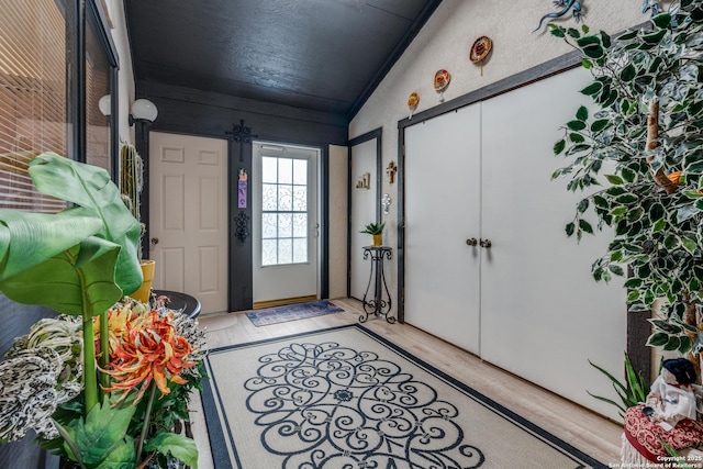 entrance foyer featuring light wood-type flooring and vaulted ceiling