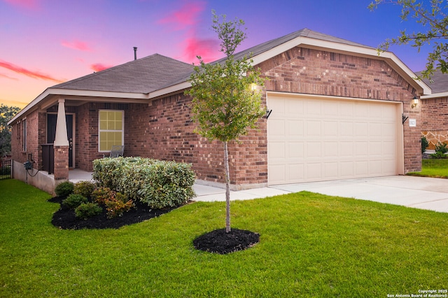 single story home featuring a garage and a yard