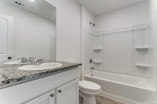 full bathroom with toilet, hardwood / wood-style floors, vanity, and bathing tub / shower combination