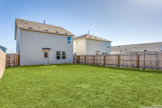 rear view of property with a yard