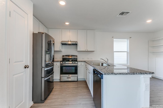 kitchen featuring kitchen peninsula, stainless steel appliances, sink, dark stone countertops, and white cabinets