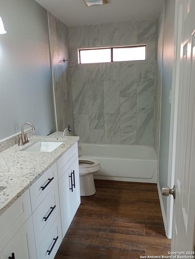 full bathroom with toilet, hardwood / wood-style floors, vanity, and tiled shower / bath