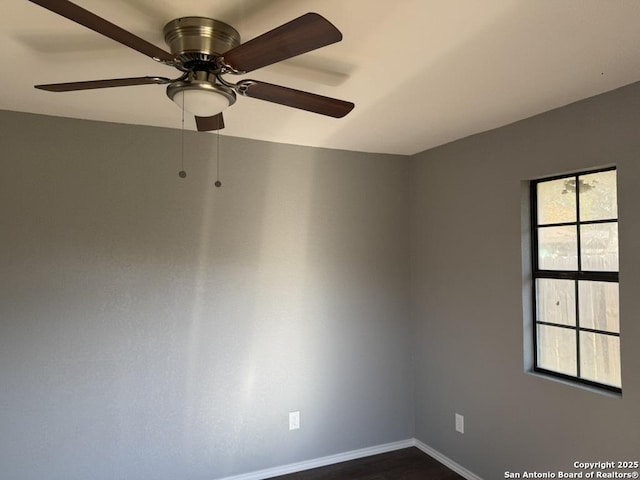 spare room featuring ceiling fan and dark wood-type flooring