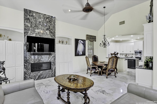 living room featuring a high end fireplace, vaulted ceiling, built in features, and ceiling fan