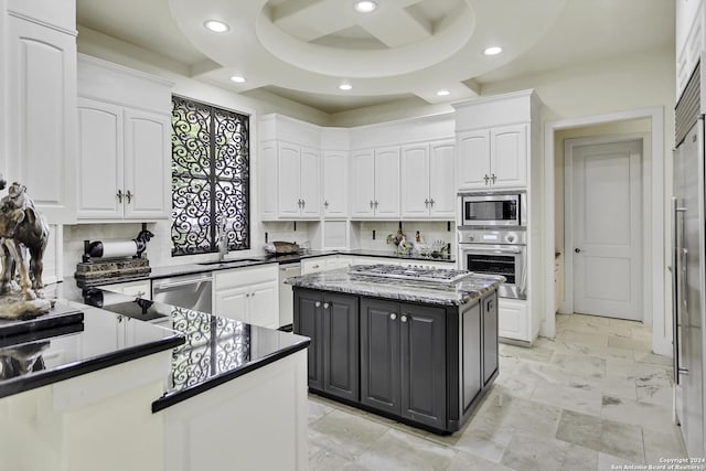 kitchen featuring backsplash, a kitchen island, white cabinetry, and stainless steel appliances