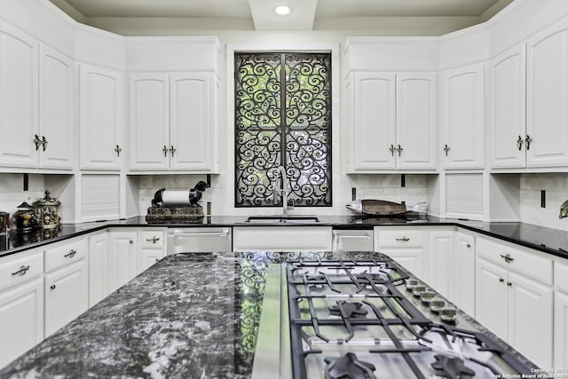 kitchen featuring dark stone countertops, white cabinetry, sink, and stainless steel gas cooktop