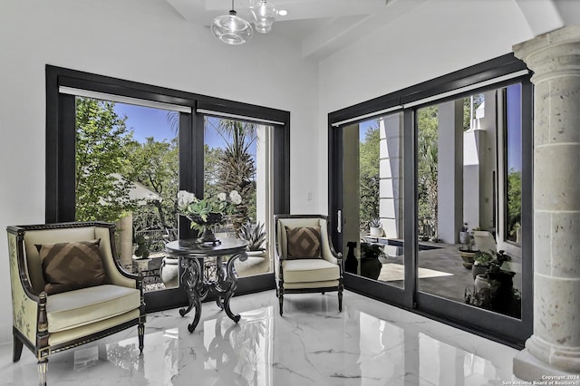 living area with a healthy amount of sunlight and decorative columns