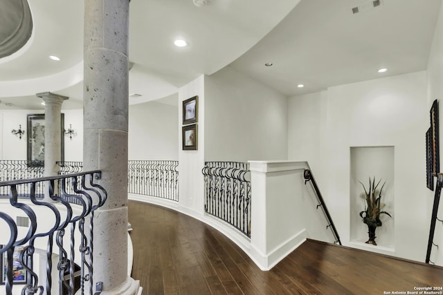 hall with hardwood / wood-style floors and decorative columns