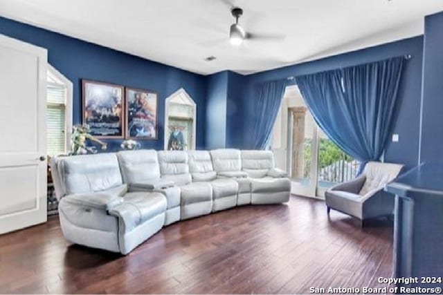 living room featuring ceiling fan and dark wood-type flooring