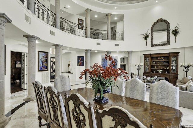 dining room featuring ornate columns and a high ceiling