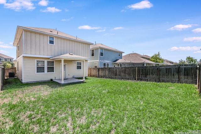 rear view of property with central air condition unit, a patio area, and a lawn