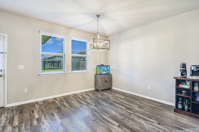 unfurnished dining area featuring a chandelier and dark hardwood / wood-style floors