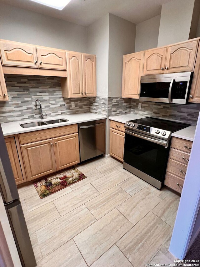 kitchen with decorative backsplash, appliances with stainless steel finishes, light brown cabinets, and sink