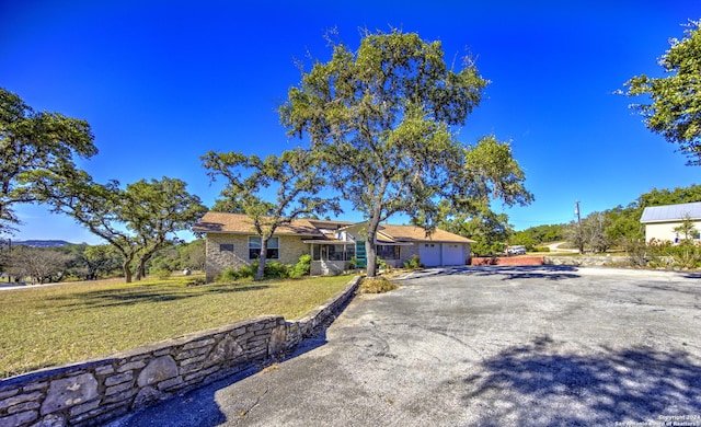 ranch-style home featuring a garage and a front lawn