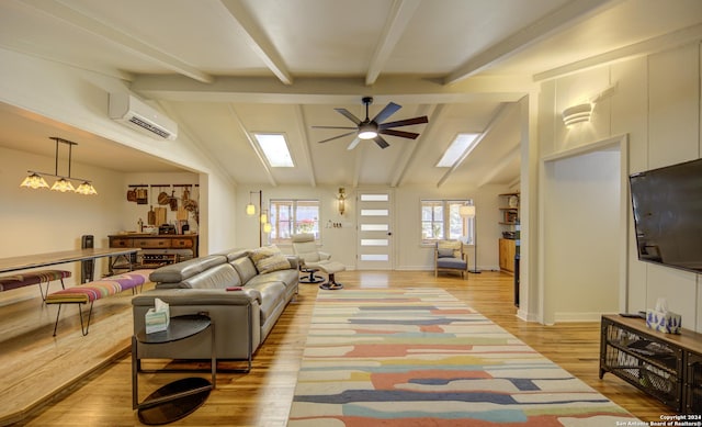 living room featuring ceiling fan, a wall mounted AC, light hardwood / wood-style floors, and vaulted ceiling with beams