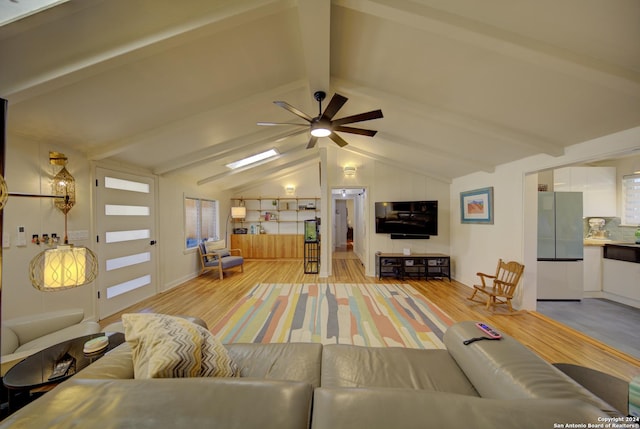 living room with vaulted ceiling with beams, ceiling fan, and light hardwood / wood-style floors