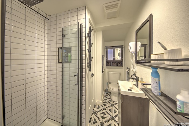 bathroom with toilet, a shower with door, and vanity