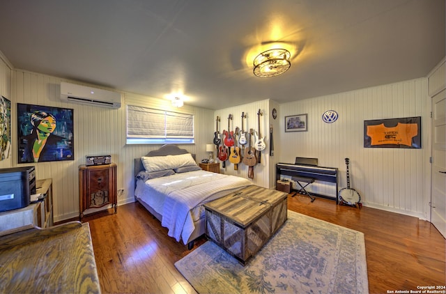 bedroom featuring a wall unit AC and dark hardwood / wood-style flooring