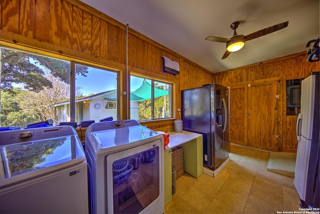 laundry area featuring wooden walls, ceiling fan, and independent washer and dryer