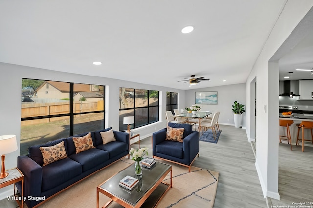 living room featuring ceiling fan and light hardwood / wood-style floors