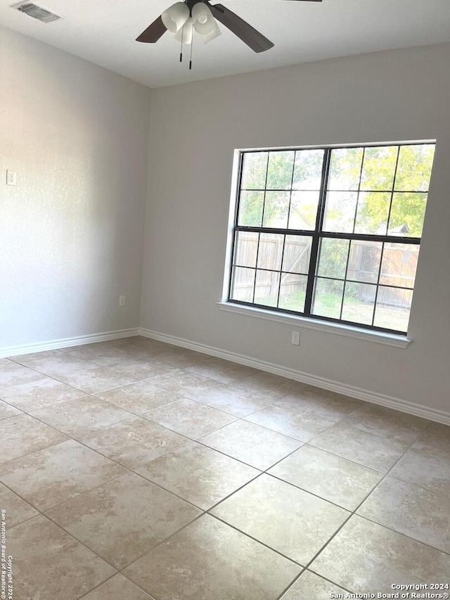 empty room with ceiling fan and a healthy amount of sunlight