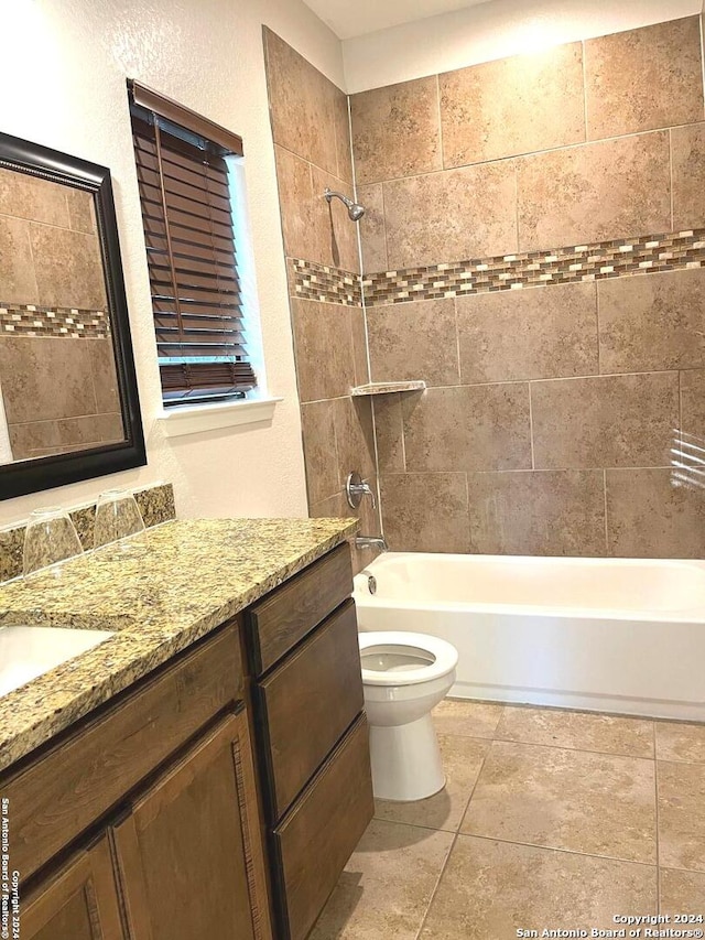 full bathroom featuring vanity, tiled shower / bath combo, and toilet