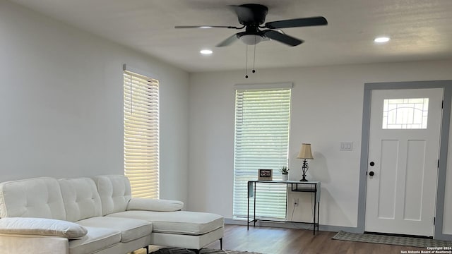 living room featuring dark hardwood / wood-style flooring and ceiling fan