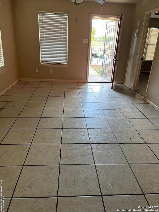 unfurnished room featuring light tile patterned floors and ceiling fan