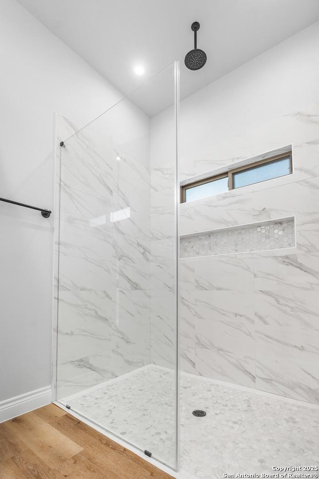 bathroom featuring wood-type flooring and tiled shower