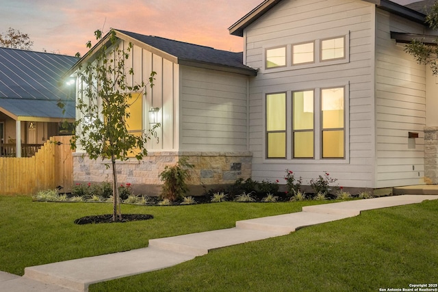 property exterior at dusk with a lawn