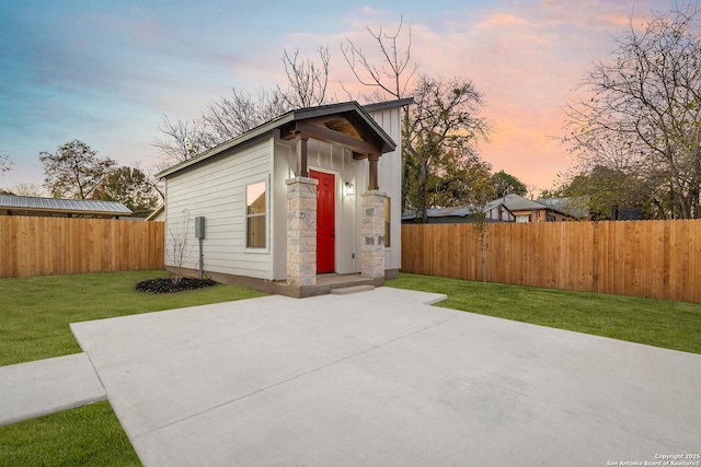 outdoor structure at dusk featuring a yard