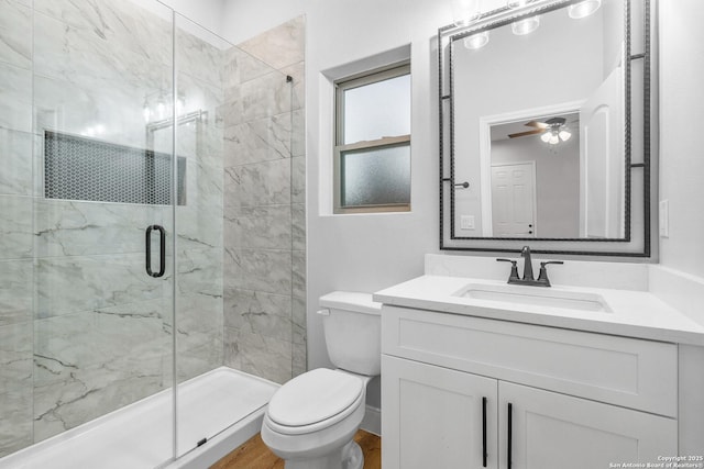 bathroom featuring ceiling fan, toilet, vanity, and walk in shower