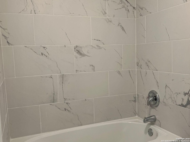 bathroom featuring tiled shower / bath