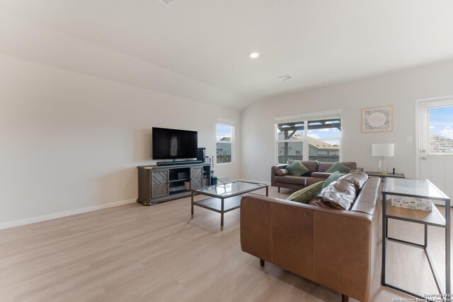 living room with light hardwood / wood-style floors and lofted ceiling