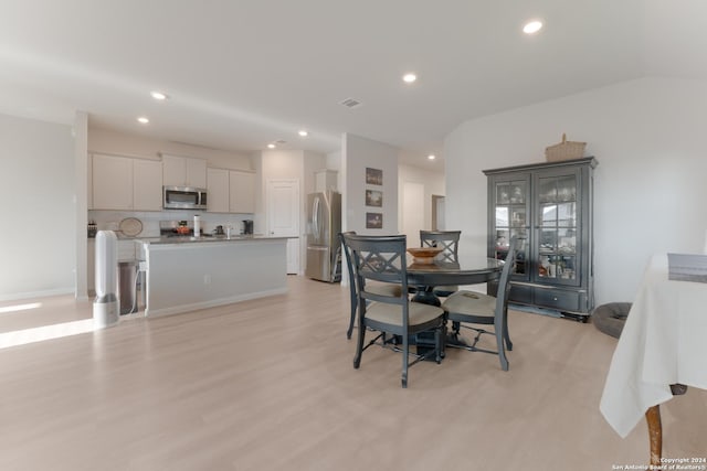 dining area with light hardwood / wood-style flooring and lofted ceiling