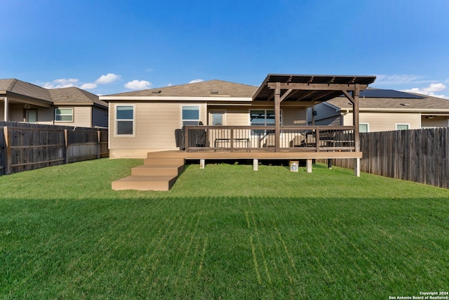 back of property featuring a pergola, a deck, and a lawn