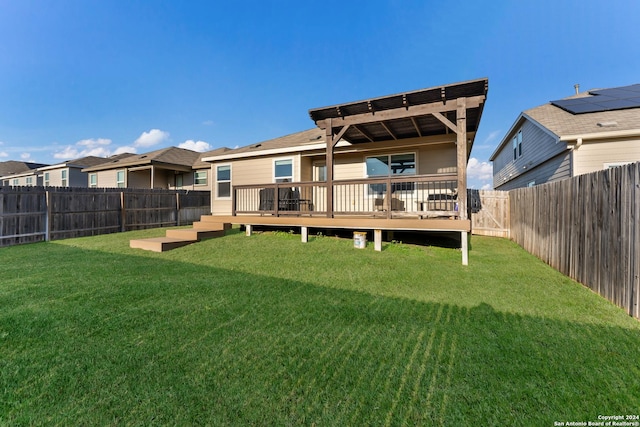 rear view of house featuring a yard, a deck, and a pergola