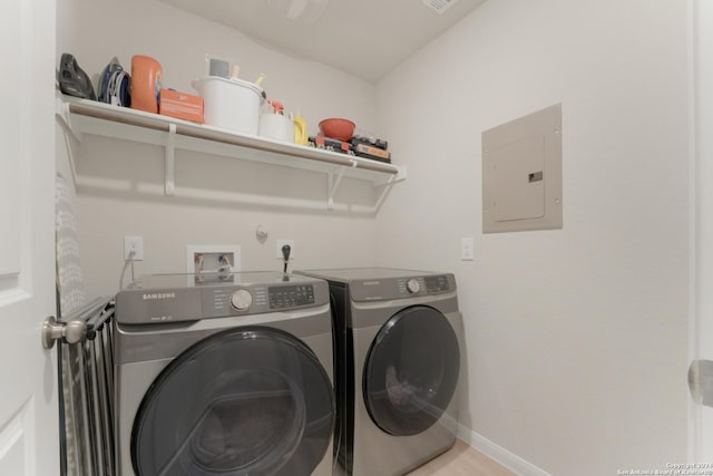 washroom with electric panel and washer and clothes dryer